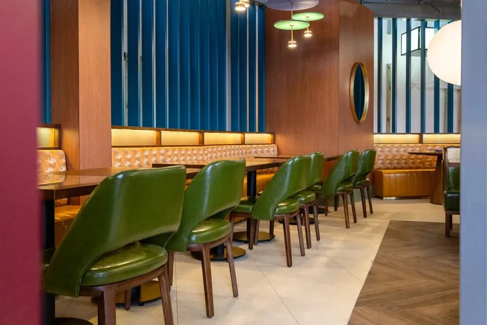 Green leather booths and cane chairs at Jade Room