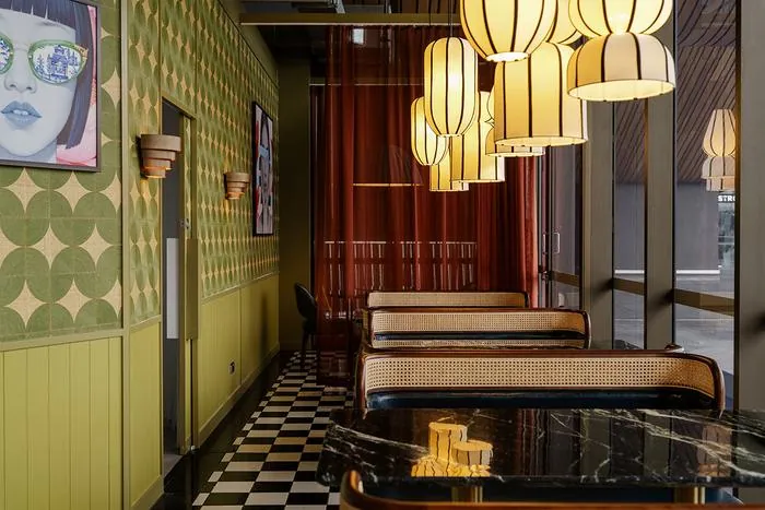 Olive banquettes, checker floor and glowing lanterns